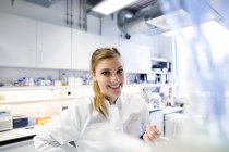 Jeune femme scientifique travaillant au laboratoire biologique — Photo de stock