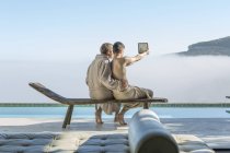 Schwules Paar am Pool macht ein Selfie mit digitalem Tablet — Stockfoto