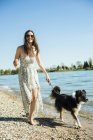 Giovane donna che cammina con il cane al fiume Reno, Germania, Mannheim — Foto stock