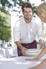 Waiters setting up an outdoor restaurant table — Stock Photo