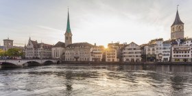Швейцария, Цюрих, Мбаппе с рекой Лиммат, мюнстерской церковью и церковью Святого Петра вечером — стоковое фото