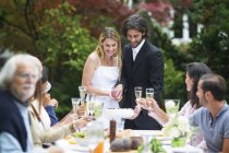 Sposa e sposo taglio torta nuziale su una festa in giardino — Foto stock