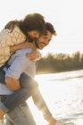 Happy young couple having fun at the riverside — Stock Photo