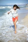 South Africa, happy woman running along the beach at seafront — Stock Photo