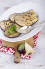 Жареные ломтики баклажанов на тарелке на деревянной доске — стоковое фото