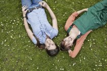 Giovani donne sdraiate sull'erba, sorridenti — Foto stock