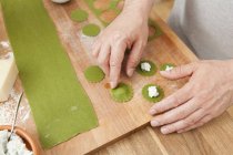 Man preparing green ravioli with ricotta — Stock Photo