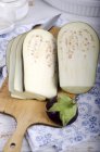 Frische Auberginen in Scheiben geschnitten auf einem Holzschneidebrett — Stockfoto