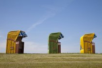 Germany, Lower Saxony, Eastern Friesland, Butjadingen, Burhave, three roofed wicker beach chairs — Stock Photo
