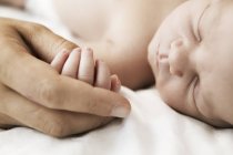 Матері, тримаючи руку її спальні новонародженого сина — стокове фото
