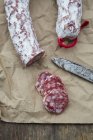 Sliced Italian salami on baking paper — Stock Photo