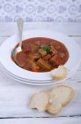 Goulash soup with bread on wooden table — Stock Photo