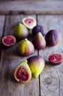 Whole and sliced fresh figs on wooden table — Stock Photo