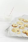 Cranberry cookies on grill rack with glass of milk — Stock Photo
