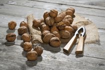 Волоські горіхи, Лускунчик та мішковину на дерев'яні таблиці — стокове фото