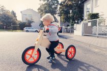 Bambino con triciclo in legno — Foto stock