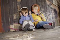 Lächelnde Jungen, die auf dem Spielplatz Musik hören — Stockfoto