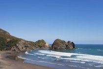 Nuova Zelanda, Veduta della roccia delle suore sulla spiaggia di Piha con pietre sopra l'acqua — Foto stock