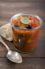 Jar with tomato sauce, black olives and leaves of basil — Stock Photo