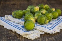 Brussels sprouts on dark wooden table with fabric — Stock Photo