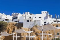 Portugal, Lagos, white houses on cliff next to beach — Stock Photo