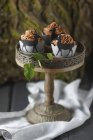 Cupcakes topped with chocolate buttercream and wrappers decorated with deer figurines on cake stand — Stock Photo