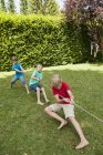 Boys playing tug-of-war on a birthday party — Stock Photo