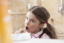 Дівчина чистити зуби у ванній кімнаті — стокове фото