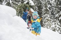 Семейная прогулка по снегу и вытягивание елки, Альтенмаркт-Заухензе, Зальцбург, Австрия — стоковое фото