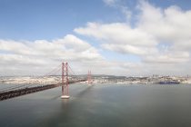 Puente 25 de Abril cruzando el río Tajo en Lisboa - foto de stock