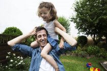 Vater mit seiner kleinen Tochter auf den Schultern — Stockfoto