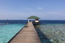Malediven, Süd-Männchen-Atoll, Embudu, Pier mit Scheune im Hintergrund über Wasser — Stockfoto