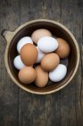 Eggs in bowl on wooden table — Stock Photo