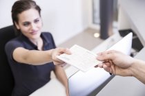 Réceptionniste remettant une ordonnance au patient — Photo de stock