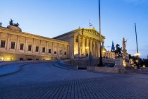 Austria, Vienna, driveway to lighted parliament building at twilight — Stock Photo