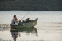 Germany, Rhineland-Palatinate, Laacher See, father and son fishing from boat — Stock Photo
