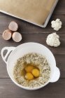 М'ясна цвітна капуста з яйцями в мисці поруч з випічкою — стокове фото