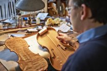 Nahaufnahme eines Geigenbauers, der in einer Werkstatt arbeitet — Stockfoto