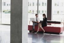 Geschäftsmann und Geschäftsfrau reden in Büro-Lobby — Stockfoto