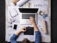 Architect working at desk with laptop, making sketches — Stock Photo