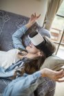 Young woman at home using Virtual Reality goggles — Stock Photo