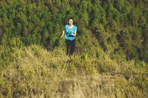 Jeune joggeuse en mouvement devant la forêt — Photo de stock