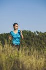 Jovem jogger feminino em movimento na frente da floresta — Fotografia de Stock