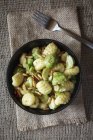 Closeup of bowl of Brussels sprouts gnocchi with pine nuts on jute — Stock Photo