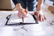 Architect making notes in his personal organizer — Stock Photo