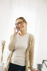 Frau telefoniert mit Smartphone im modernen Home Office — Stockfoto