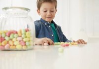 Хлопчик з цукерки jar, підрахунок цукерки — стокове фото