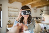Young woman at home using Virtual Reality goggles — Stock Photo