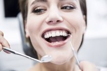Woman at the dentist receiving treatment — Stock Photo