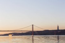 Portugal, Lisboa, Vista da Ponte 25 de Abril no Rio Tejo ao pôr-do-sol — Fotografia de Stock